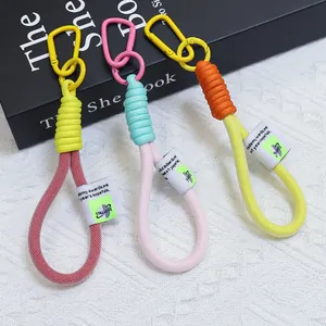 Dettaglio di tre cordini intrecciati colorati per telefono con moschettoni metallici.