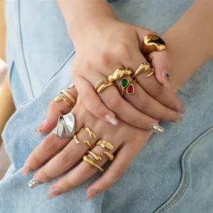 Close-up of chunky gold-tone stainless steel rings with geometric and snake designs