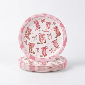 Close-up detail of pink cowgirl themed party paper plates with boot and bow patterns
