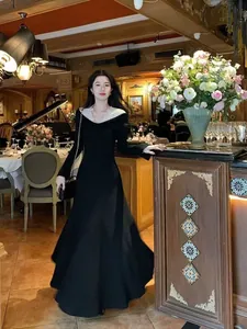 Robe longue noire style français élégante avec col en dentelle blanche chic.