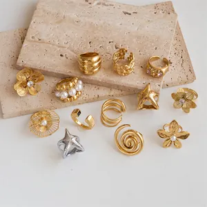 Collection of gold-plated stainless steel rings featuring flower, starfish, and geometric motifs