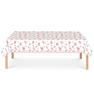 Detailed view of the pink cowboy theme party tablecloth with boots and hats pattern.