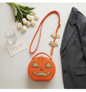 Close-up of a creative orange pumpkin shoulder bag with glitter bat strap detail