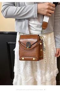 Primo piano borsa a tracolla marrone coccodrillo con elegante tracolla larga in tessuto