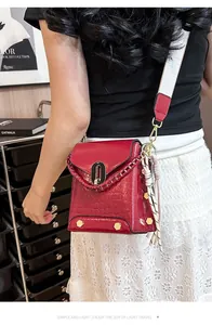 Borsa a tracolla rossa chic con trama a coccodrillo e tracolla larga, vista su modella