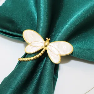 Elegante portatovagliolo a libellula dorata con smalto beige su raso verde scuro