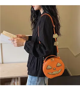 Close-up detail of a stylish woman wearing an orange pumpkin-shaped Halloween bag.