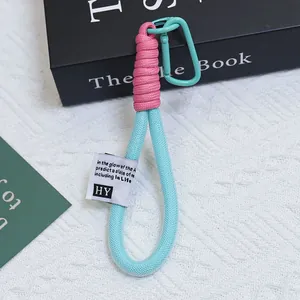 Dettaglio di portachiavi in corda intrecciata con guaina a rete in colori rosa e blu