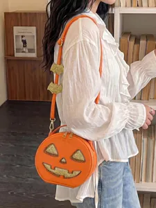 Model wearing a creative Halloween pumpkin-shaped crossbody bag with glittery details