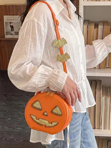 Close-up view of a creative pumpkin-shaped shoulder bag featuring glittery details