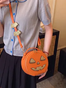 Trendy Jack-o'-lantern crossbody bag for Halloween party with glittery bat decorations.