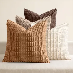 Close-up detail of textured corduroy striped pillow covers in assorted earthy tones on a sofa