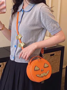 Detailed shot of a quirky Halloween pumpkin crossbody bag with glitter charms on model