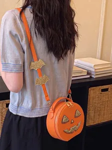 Detailed view of a creative orange pumpkin crossbody bag with festive glitter bat strap.