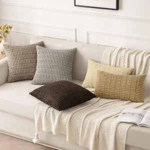 Lifestyle detail of textured corduroy cushion covers with wheat spike pattern on a sofa