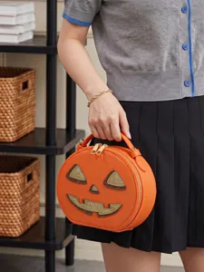 Creative Halloween pumpkin-shaped handbag with glitter face detail held by a model
