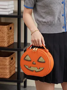 Stylish lifestyle view of a creative Halloween pumpkin shaped crossbody bag held by a model