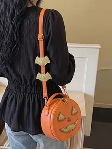 Rear view of model wearing a festive orange pumpkin crossbody bag with bat strap