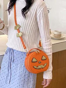 Detailed view of a creative orange pumpkin crossbody bag with glittery bat accents