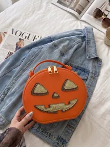 Trendy orange Halloween pumpkin handbag styled on denim jacket with VOGUE magazine