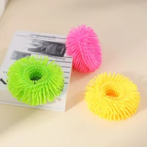 Detailed view of colorful soft silicone puffer ring stress relief toys on a book
