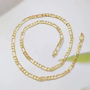 Close-up of a gold-plated Figaro chain necklace with a lobster clasp