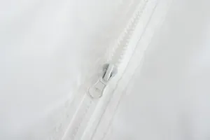Macro view of a white zipper on a breathable lightweight hooded jacket