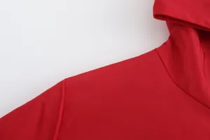 Close-up detail of the shoulder and hood on a vibrant red breathable sports jacket.