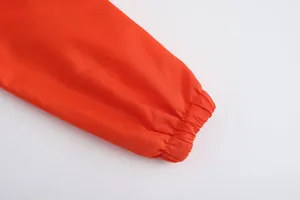 Detailed close-up of elasticated orange cuff on breathable thin men's sports jacket