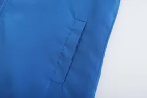 Detailed view of the side pocket stitching on a blue breathable lightweight jacket.