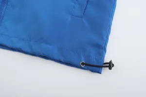 Detailed macro view of blue sports jacket hem with adjustable drawstring and black toggle