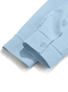 Detailed close-up view of a light blue cotton linen men's shirt cuff with button