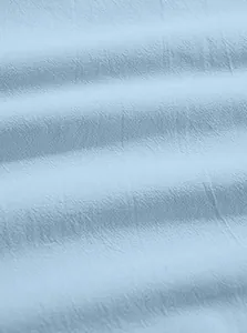 Close-up of light blue cotton linen fabric showing breathable texture and soft grain