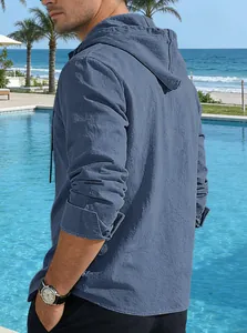 Side view of a men's blue hooded linen shirt with breathable texture in a resort setting