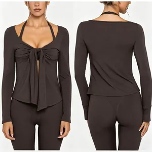 Detail of brown long-sleeve yoga top featuring tie-front bow and halter neckline.