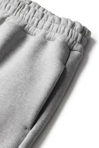 Detailed view of grey fleece-lined joggers featuring elastic waistband and side pocket