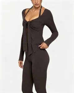 Detail of a dark brown front-tie yoga jacket with long sleeves and deep V-neck.
