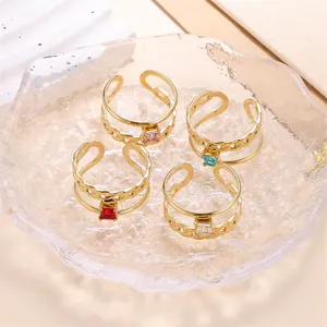Detailansicht von vier verstellbaren Edelstahlringen mit bunten Zirkoniasteinen in 18k Gold.