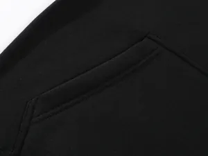 Macro view showing the pocket design and soft fleece fabric texture of black loose pants