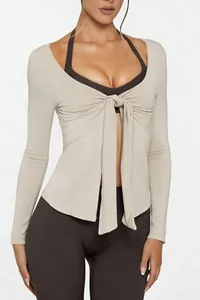 Macro view of front-tie design on beige long-sleeve yoga top for fitness wear