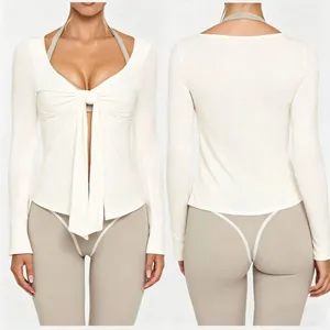 Detailed view of white tie-front yoga top showing front and back fit on model