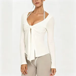 Close-up of the front tie detail on a white long sleeve yoga top with V-neck line style