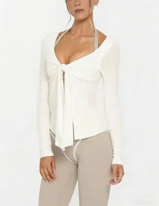 Close-up detail of a white tie-front long sleeve yoga jacket with V-neck fitness design