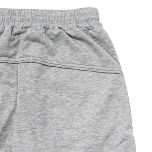 Detail shot showing the elastic waistband and side pocket of grey athletic joggers.