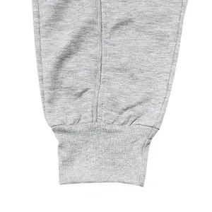 Close-up detail of the ribbed ankle cuffs on light grey men's athletic jogger sweatpants
