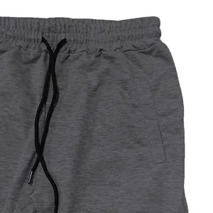 Detail view of dark gray men's athletic sweatpants waist with black drawstring closure