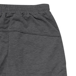 Close-up detail of grey athletic sweatpants showing elastic waistband and side pocket