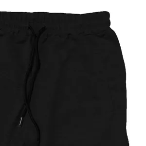 Detail showing the elastic waistband and drawstring of black sports sweatpants