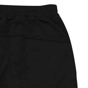 Macro detail showing the elastic waistband and stitching of black men's sport joggers.