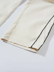 Detailansicht des Beinabschlusses einer cremefarbenen Techwear-Hose mit schwarzer Paspelierung
